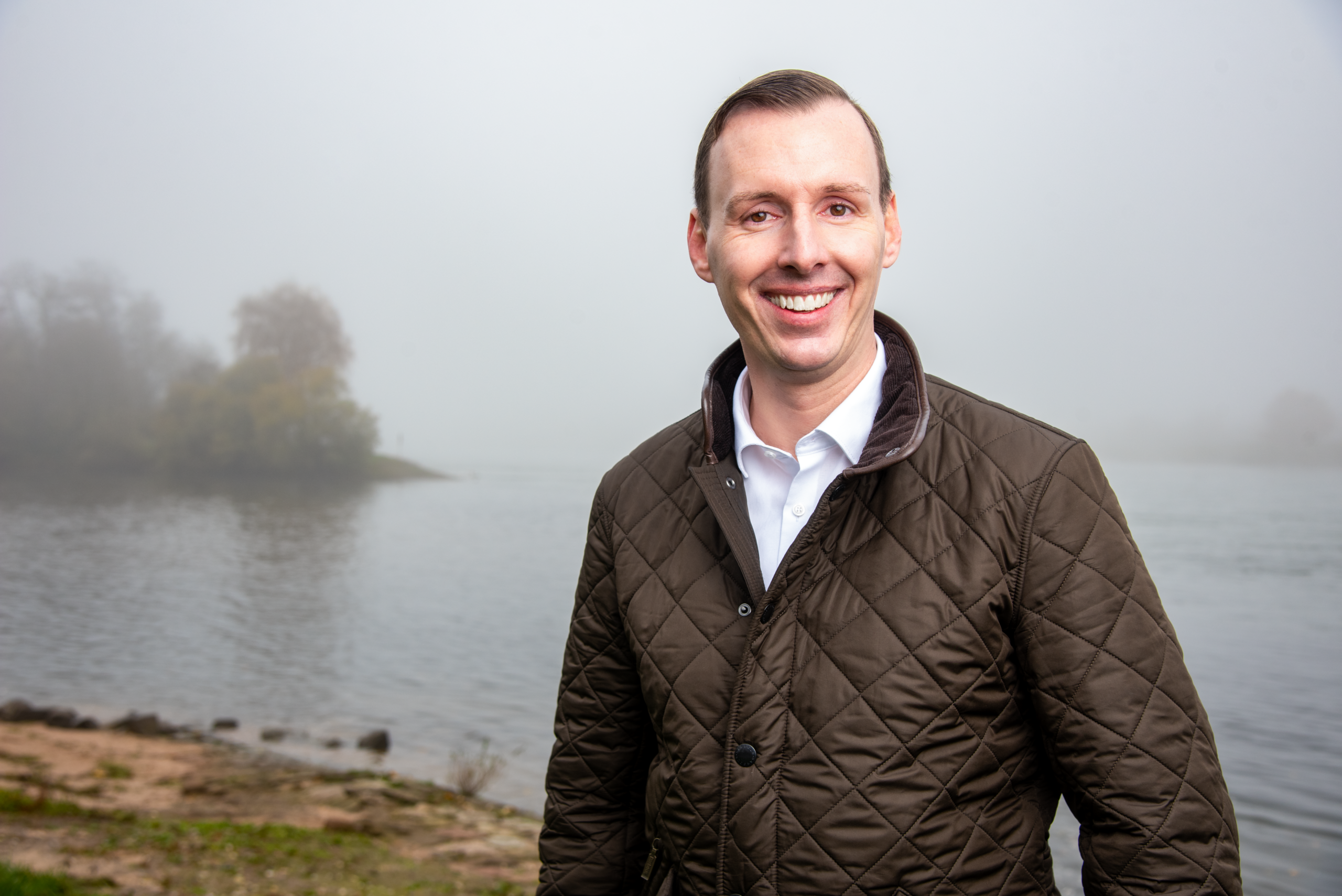 Landtagskandidat Philipp Helber (AfD) aus dem Wahlkreis Rastatt an der Murgmündung Steinmauern bei Rastatt – authentisches Porträt mit dem Rhein im Hintergrund und bürgernahem Charakter.